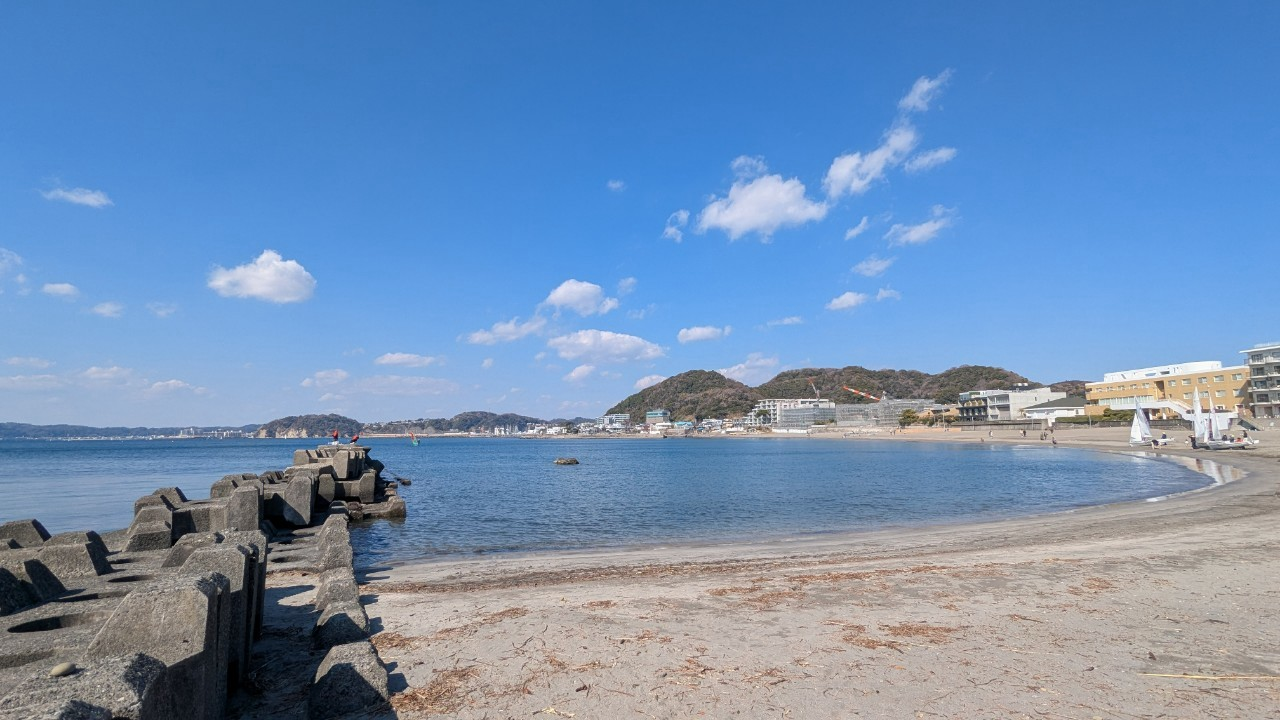 テトラポッドごしに見える葉山の海と、遠くに広がる街並みと山