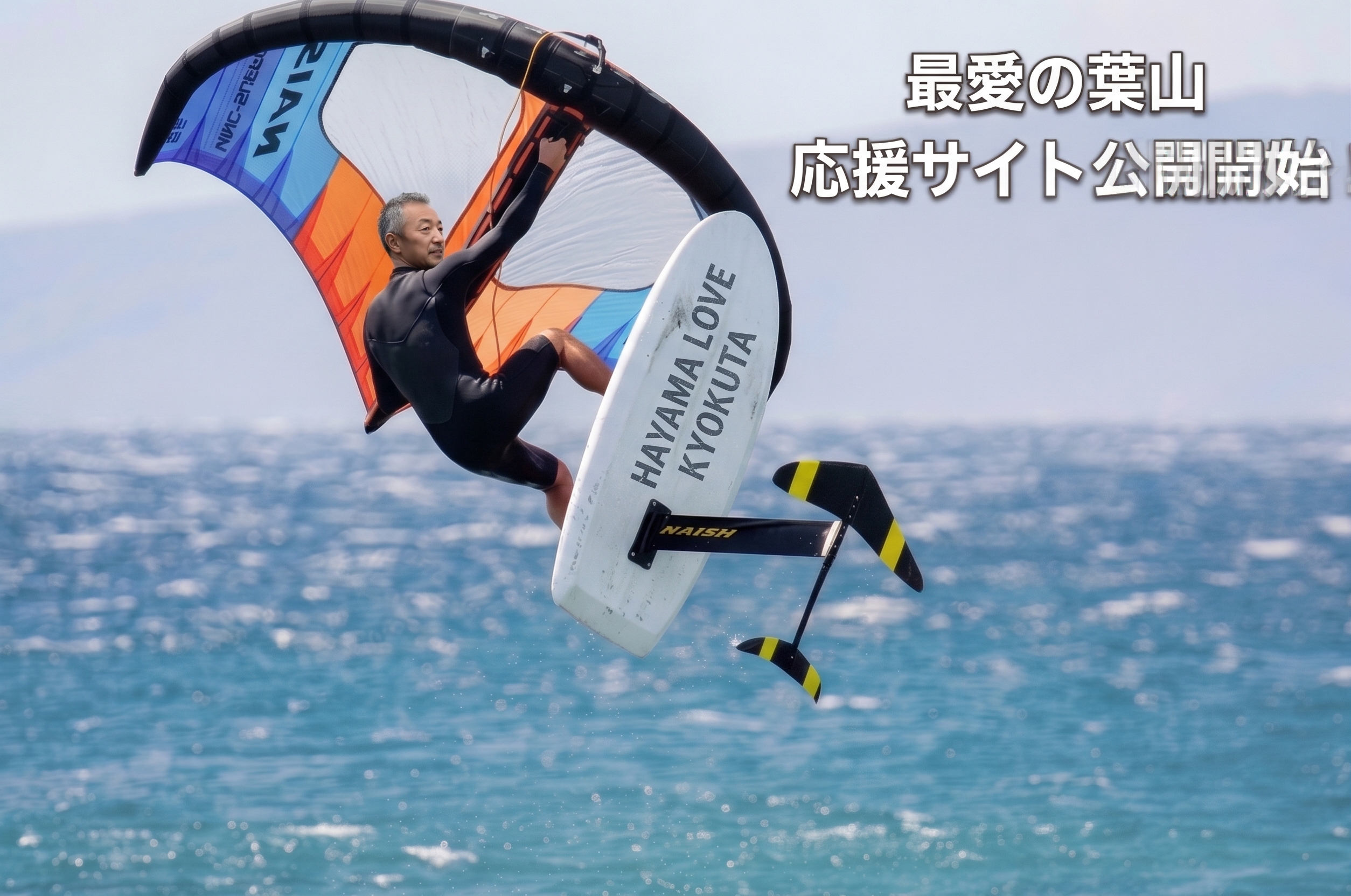 ウイングフォイルを楽しむ曲田和史と「最愛の葉山 応援サイト公開開始」の文字